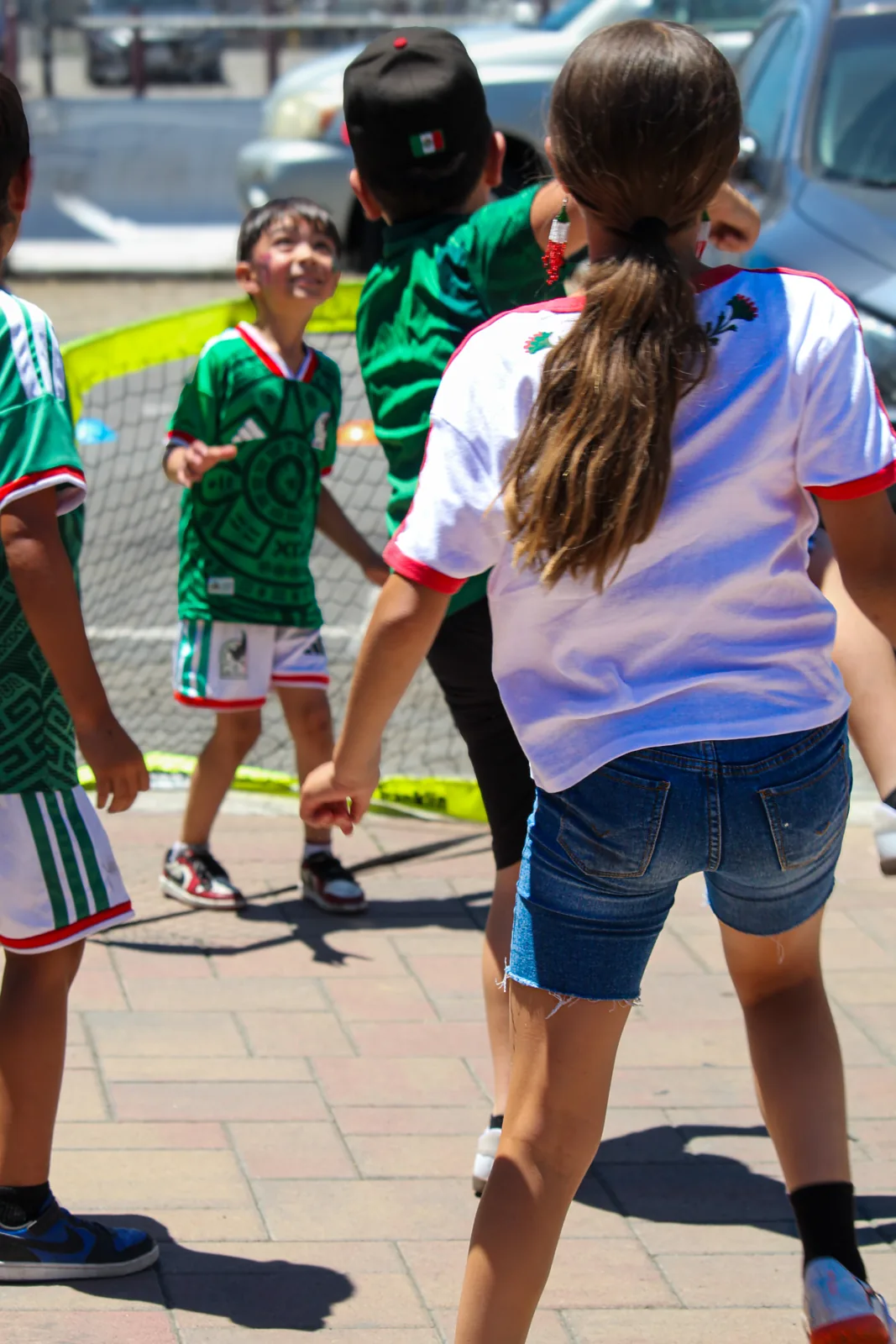Kids in Mexico jerseys playing fútbol at an Our Copa youth clinic